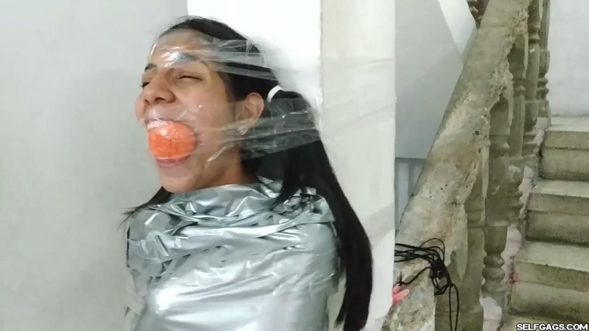 Cute girl gets duct tape mummified BDSM training by female bondage photographer