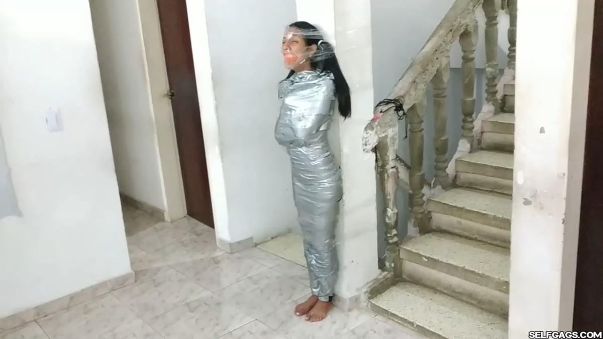 Cute girl gets duct tape mummified BDSM training by female bondage photographer