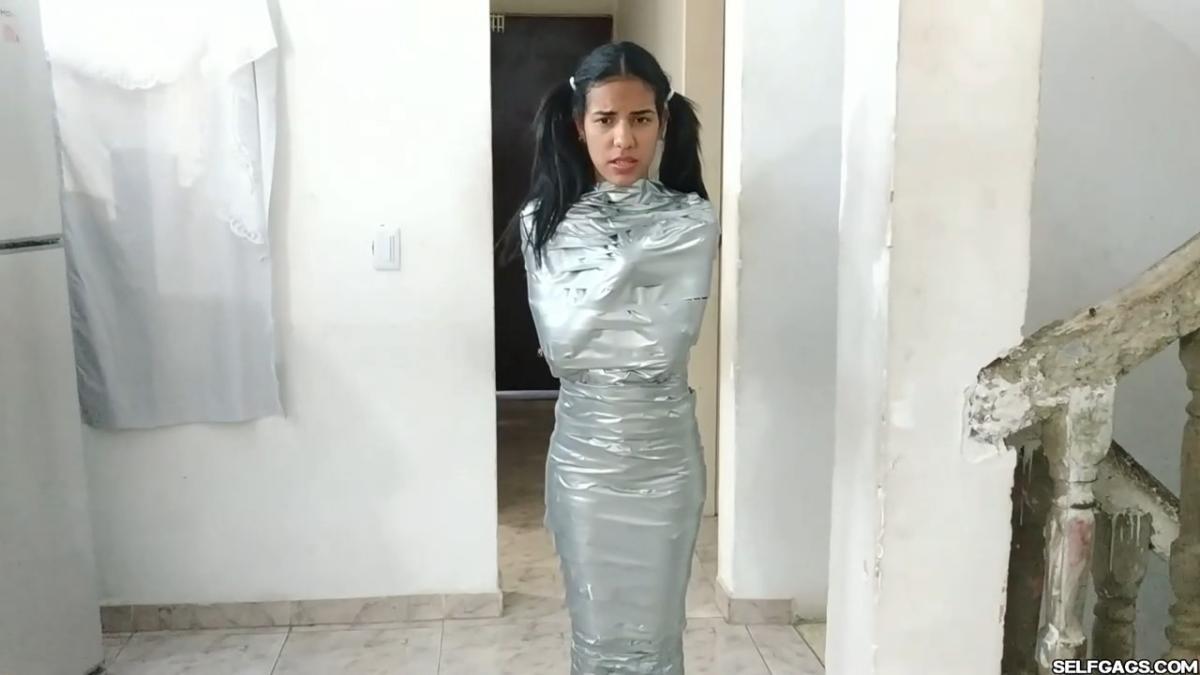 Cute girl gets duct tape mummified BDSM training by female bondage photographer
