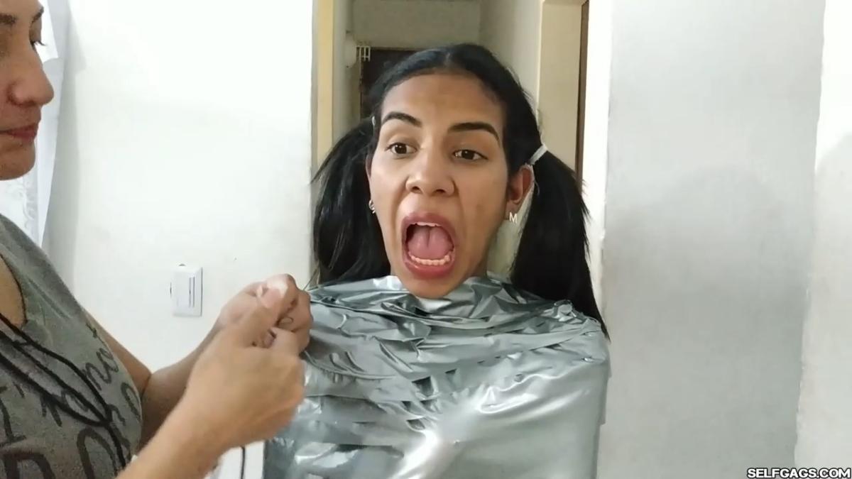 Cute girl gets duct tape mummified BDSM training by female bondage photographer
