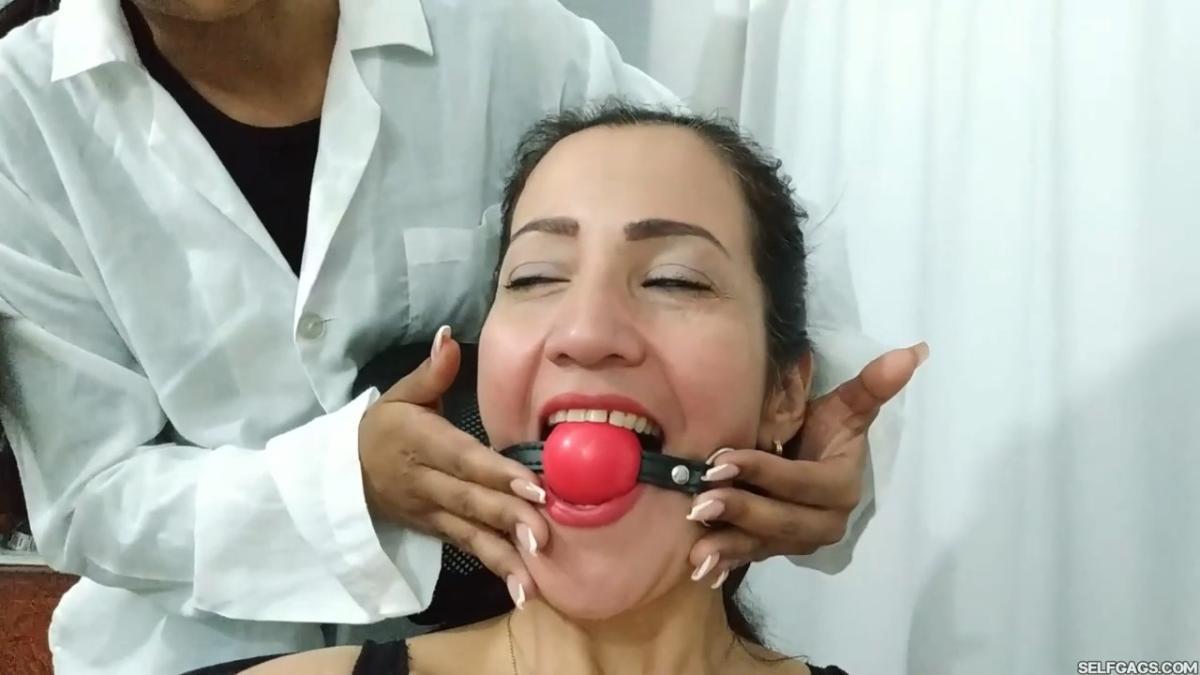 Young massage girl does foot massage on bound and gagged woman with sensual foot worship