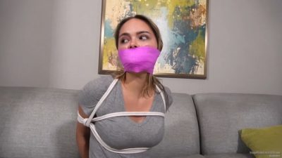 Rosie Satin with thick purple vet wrap sealed over her mouth and white rope chest harness – Bound To Be Gagged