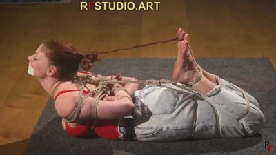 Side view of Emily's rope hogtie with a hair-to-toe cord pulling her head back