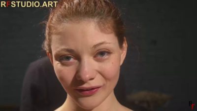 Ungagged ID — Emily Stone looking into the camera, red hair pulled back, before the ropes go on