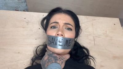 Close-up of Tatti with “SAVE ME!” duct tape gag as tattooed man grabs her throat – Tatti Roana Bondage