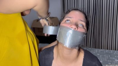Close up of Lau wrapping multiple layers of duct tape over Nana’s panties stuffed mouth Selfgags