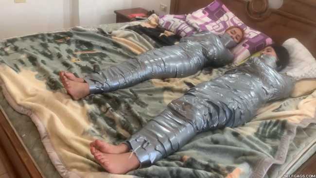 Barefoot girls gagged in tight duct tape mummification bondage