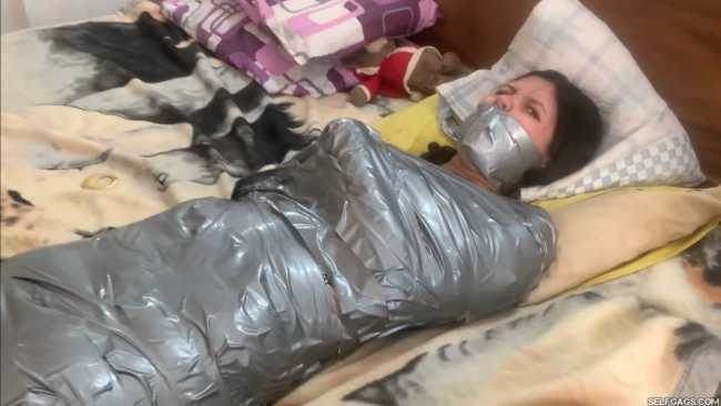 Angry girl gagged in tight duct tape mummification bondage