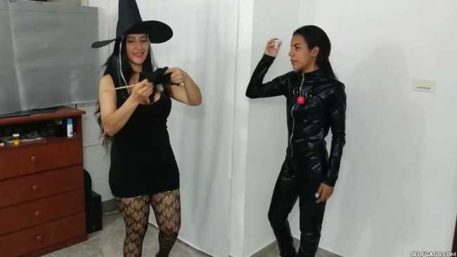 girl in catsuit bound and gagged by witch and cheerleader for halloween