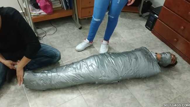 Gagged girl in duct tape mummification bondage