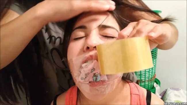 Girl has her mouth gagged with many socks