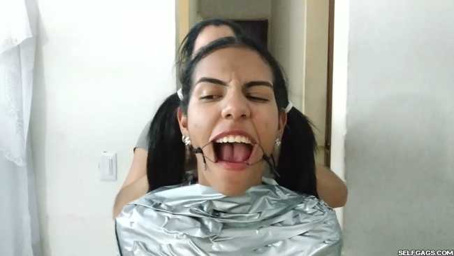 Cute girl gets duct tape mummified BDSM training by female bondage photographer