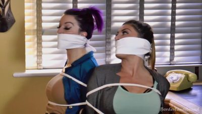 Back-to-back CU — Roxxi purple profile and Carmen mint top, thick white cloth OTM gags and white chest rope against the blinds