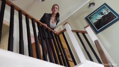 Nikki Foxx ungagged face ID on the stair landing in a black blazer over a white tank