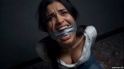High angle shot of crying brunette with silver duct tape cleave gag baring her teeth in distress