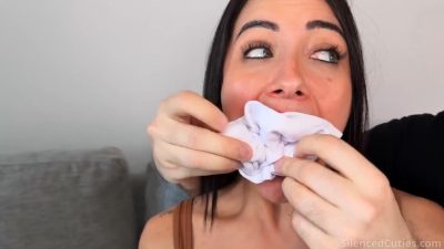 Close-up of two white socks being stuffed deep into Carlita Cruz’s open mouth before tape sealing - Silenced Cuties