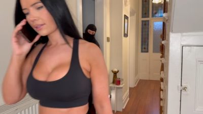 Tatti talking on phone in tight gym outfit while masked intruder hides in hallway behind her – Tatti Roana Bondage