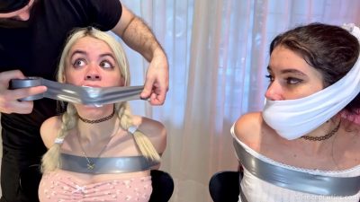 Side-by-side chair bondage — cloth-gagged Addy next to Nani as PVC tape seals Nani’s mouth